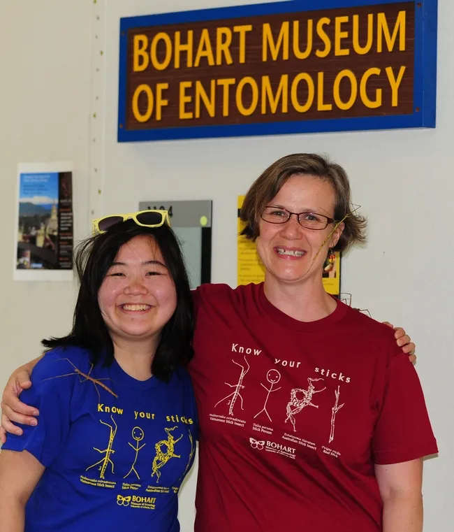Ivana Li (left) and Fran Keller wearing their "Know Your Sticks" t-shirts. Note the real walking stick insects. (Photo by Kathy Keatley Garvey)