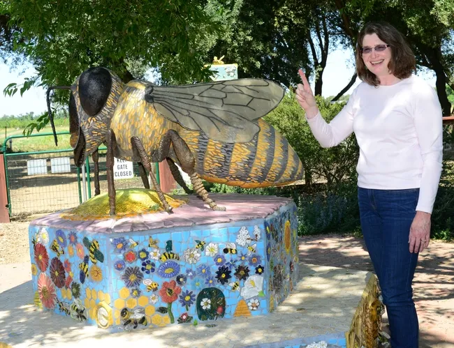 That's one pollinator! Barbara Allen-Diaz, vice president of UC ANR, holds up a finger designating one pollinator. This is Donna Billick's bee sculpture in the Haagen-Dazs Honey Bee Haven. It was funded by Wells Fargo. (Photo by Kathy Keatley Garvey)