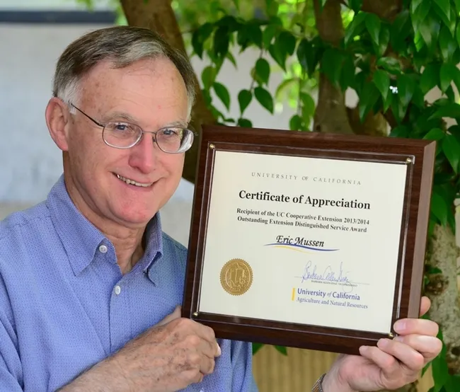 Eric Mussen with his outstanding service award from UC ANR. (Photo by Kathy Keatley Garvey)