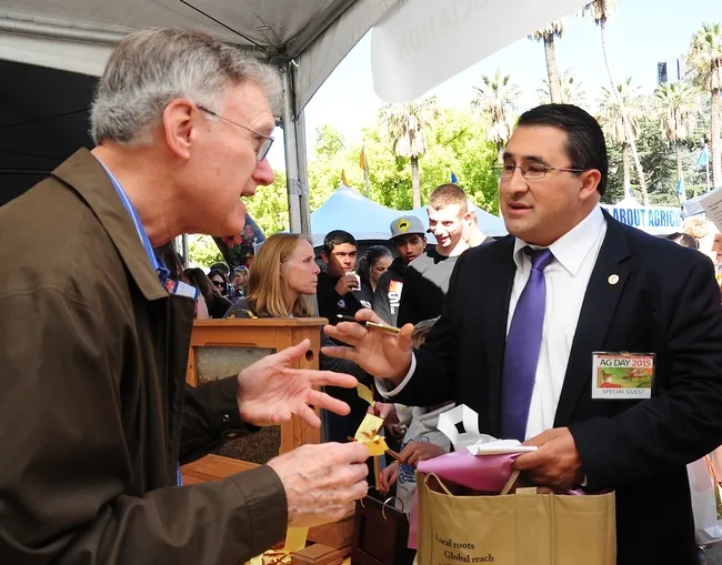 Legislative aide Tony Madrigal (right) asks Extension apiculturist emeritus Eric Mussen questions about colony health. Madrigal is an aide for Assemblyman Luis Alejo. (Photo by Kathy Keatley Garvey)