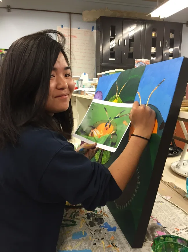 UC Davis student Kelly Aoyama works on a painting that will be displayed June 3 at a public art exhibit in Davis. (Photo by Diane Ullman)