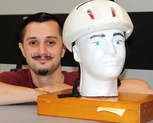 Entomology undergraduate student Wade Spencer with his Recycling Man. Inside mealworms are chewing and digesting the Styrofoam. (Photo by Kathy Keatley Garvey)