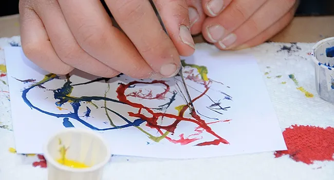 This is maggot art. Dip a maggot in water-soluble paint, let it crawl around or guide it on a white piece of paper, and voila! Maggot art. (Photo by Kathy Keatley Garvey)