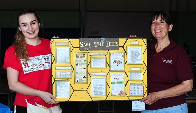 Rebecca Banducci (left), part of the McCormack Hall crew, and superintendent Gloria Gonzalez of Vallejo, show a display board crafted by Ryan Anenson of the Tremont 4-H Club, Dixon. It won a best of show. (Photo by Kathy Keatley Garvey)