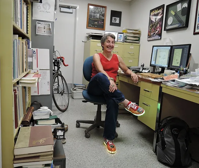 Lynn Kimsey, director of the Bohart Museum of Entomology, wearing the "magic shoes" in her office. (Photo by Kathy Keatley Garvey)