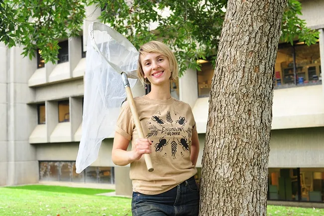 Entomologist Stacey Rice wearing her prize-winning t-shirt, "The Stag Beetles." In the background is Briggs Hall, home of the UC Davis Department of Entomology and Nematology. This t-shirt and other insect-themed shirts are available from the Entomology Graduate Students' Association. (Photo by Kathy Keatley Garvey)