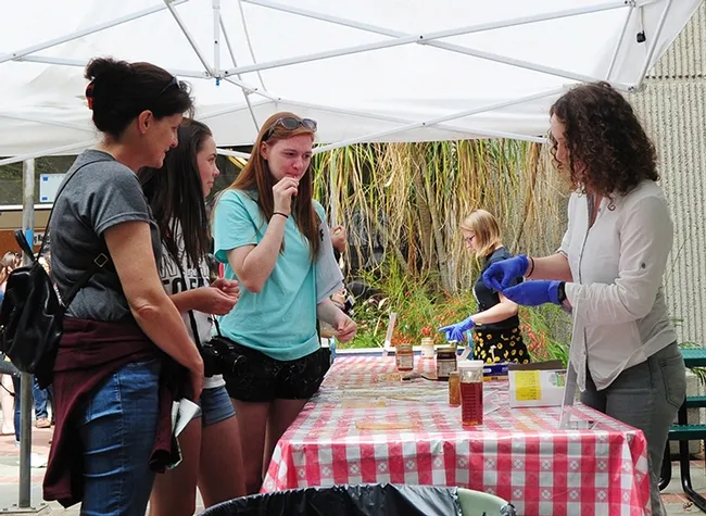 Graduate students Maureen Page (foreground) of the Neal Williams lab, and Patricia Bohls of the Elina Niño serve honey. (Photo by Kathy Keatley Garvey)