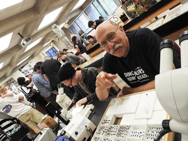 Forensic entomologist Robert Kimsey holds forth as "Dr. Death," answering forensic questions. At the microscope next to him is nematologist Corwin Parker.