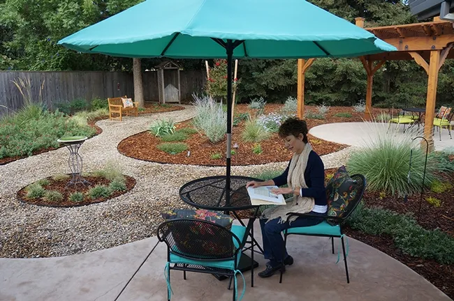 Plant and insect enthusiast Ria de Grassi of Davis, a UC Davis alumna, reads in her newly landscaped backyard, a "Life After Lawn" project. (Photo by Katie Hetrick, UC Davis Arboretum and Public Garden)