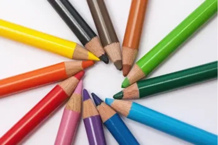 Colored pencils arranged in a circle with tips pointing inward.