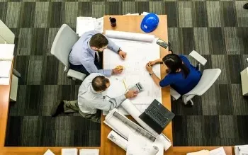 Group of employees planning on a large piece of paper at a desk.