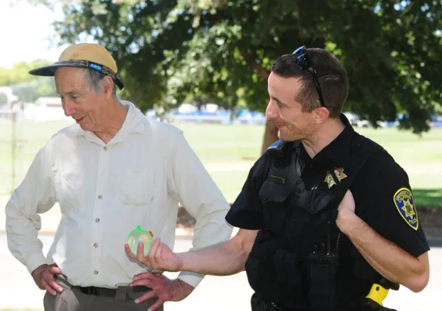 Bruce Hammock ponders tips on water balloon battling as he chats with UC Davis police officer Stephen Jerguson, who was handed a water balloon battle for