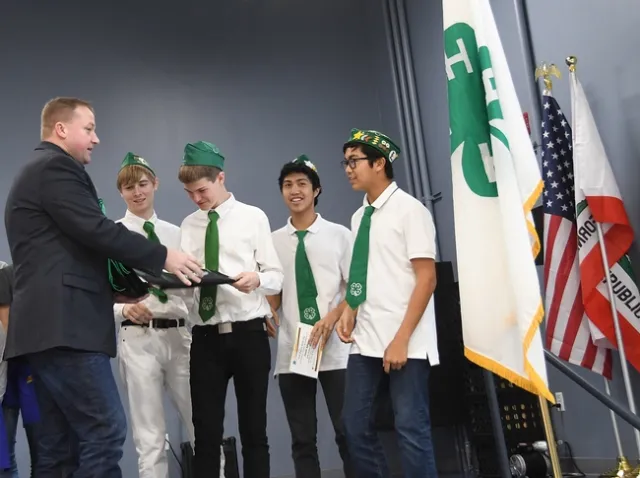 Vacaville Mayor Ron Rowlett congratulates the Chili Cowtown Boys, winner of the Solano County 4-H Chili Cook-Off. From left are Ian Weber, Xander Lovell Francis Agbayani, and Matthew Agbayani. (Photo by Kathy Keatley Garvey)