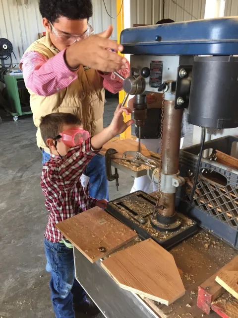 Youth volunteer assisting with woodworking project.