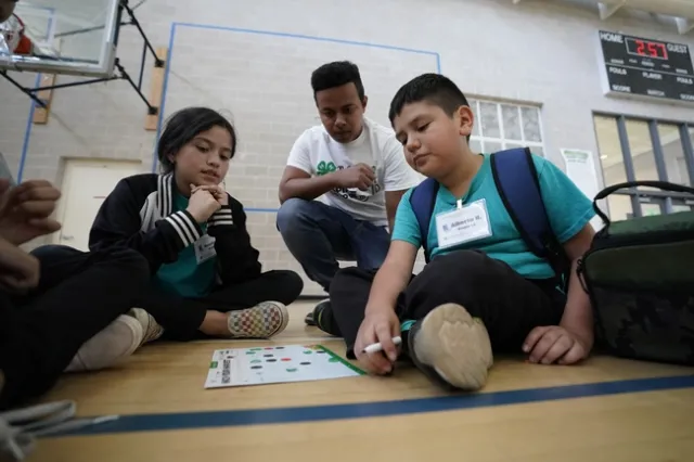 4-H Teen Teacher helping students complete the Hack Your Harvest activity.