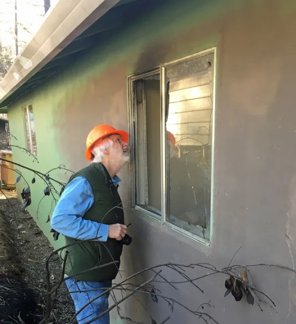 Steve Quarles, UC Cooperative Extension advisor emeritus, looks at a garage attached to an older house in Paradise where the radiant heat from a nearby fence and line of planted vegetation ignited and were sufficiently hot enough to break the single pane glass. Photo by Yana Valachovic