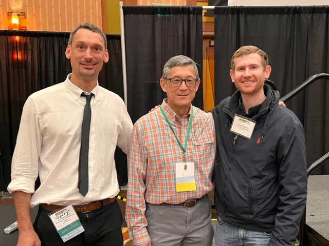 Three men standing side by side.