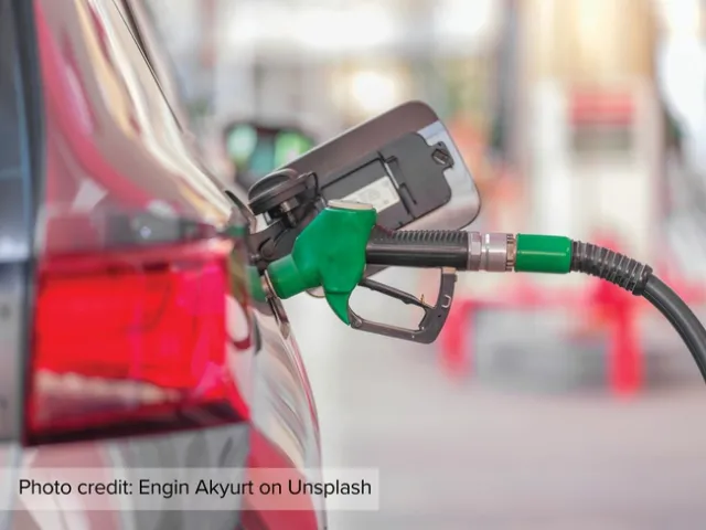 The green nozzle of a biodiesel fuel pump is inserted into a car.