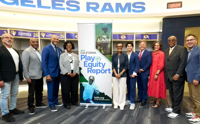 Hannah Thompson, in red dress, with legislators, advocates and experts at a special session of the CA Senate Education Committee at SoFi Stadium 