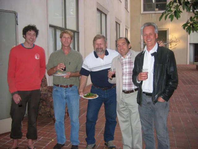 Houston Wilson in red sweatshirt stands at left with faculty members