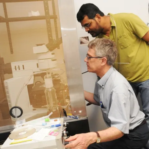 CHEMICAL ECOLOGISTS Walter Leal (foreground) and Zain Syed at work in the Leal lab in the UC Davis Department of Entomology. Leal is a professor and former chair of the department, and Syed is a postdoctoral researcher and the primary author of a paper published March 16 in PLoS One. (Photo by Kathy Keatley Garvey)