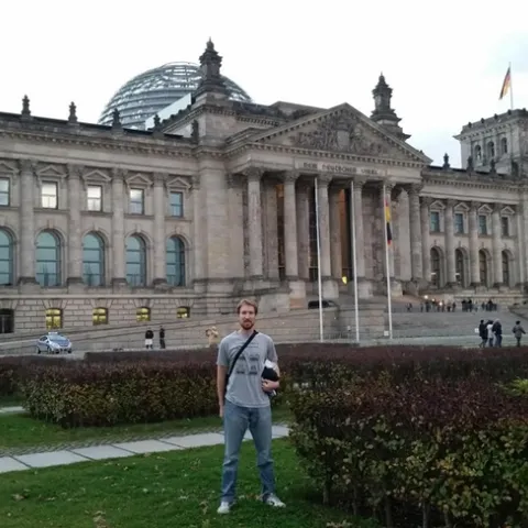 Matan Shelomi, wearing a UC Davis entomology shirt, stands in front of the Reichstag in Berlin.