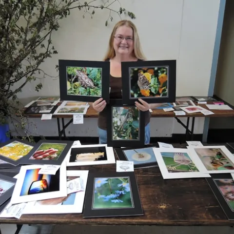 Dixon May Fair Youth Building superintendent Sharon Payne with some of the insect photographs taken by youth exhibitors.(Photo by Kathy Keatley Garvey)
