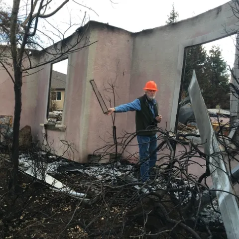 Steve Quarles and Yana Valachovic examined houses in Paradise after the devastating 2018 Camp Fire. Quarles holds up a vent screen that may have allowed embers to enter the house. Photo by Yana Valachovic
