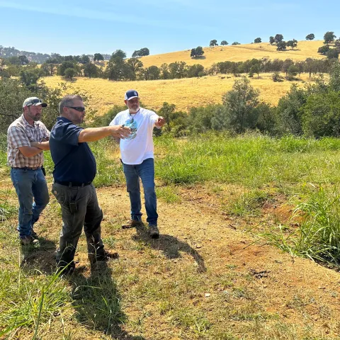 Nikolai Schweitzer gestures at the trench built into a hillside at Sierra Foothill REC