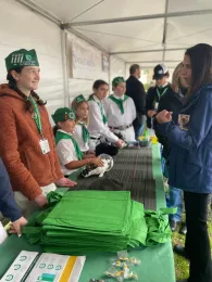 A 4-H'er in 4-H whites talks with a visitor.