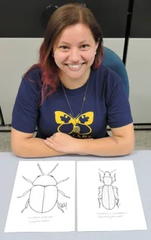 UC Davis entomology major Karissa Merritt had drawn these illustrations of sawtoothed grain beetle and a cigarette beetle for the children's arts and crafts activity. A senior, she is from Canyon Country, Los Angeles County. (Photo by Kathy Keatley Garvey)