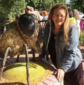 Beekeeper Sharon Schmidt stands next to the sculpture,