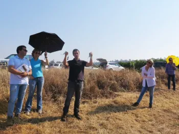 A man holding soil sensors in a vineyard.