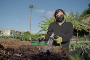 Young woman waters plants