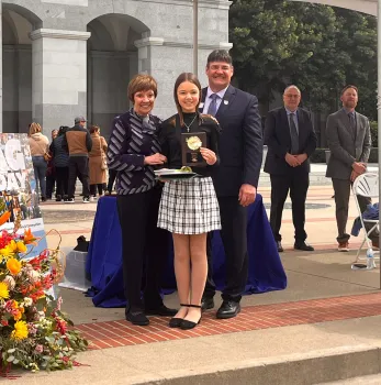 Jayna holding her award with Karen Ross and Rob Peterson