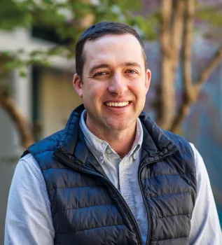 Headshot of Houston Wilson wearing a collared shirt and puffy vest