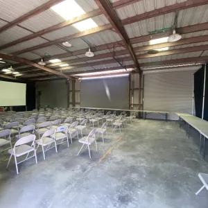 the barn set up with chairs and the projector screen for presentations, with tables around the perimeter for food and beverages